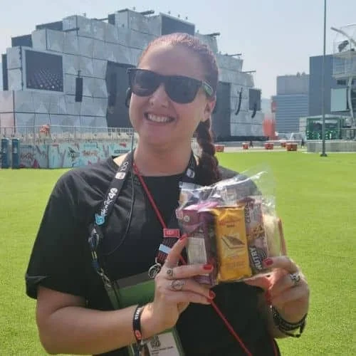 Membro de equipe de staff recebendo kit lanche individual em grande evento no Rio de Janeiro.